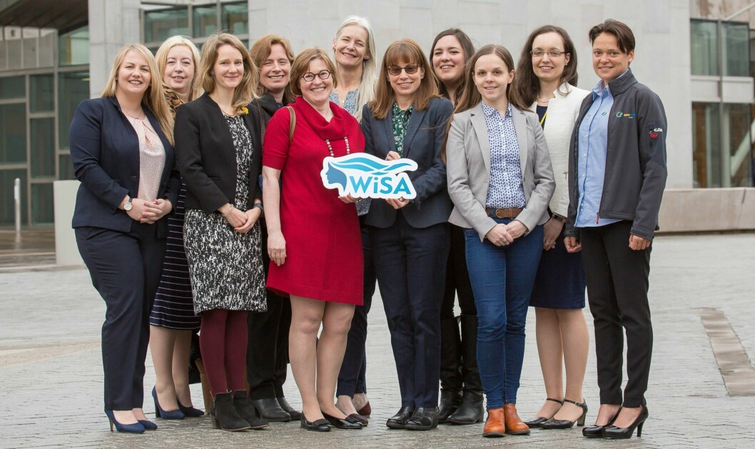 SAIC chief Heather Jones, left, and Rowena Hoare, senior researcher at the IoA, hold the WiSA logo as women working in Scottish aquaculture celebrate the launch of the organisation outside the Scottish Parliament. Photo: WiSA.