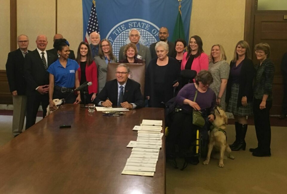 Jay Inslee signs a number of bills into law, including phasing out non-native fish farms, setting standards for service animals, and increasing awareness for bone marrow donation, on Thursday. Photo: Twitter