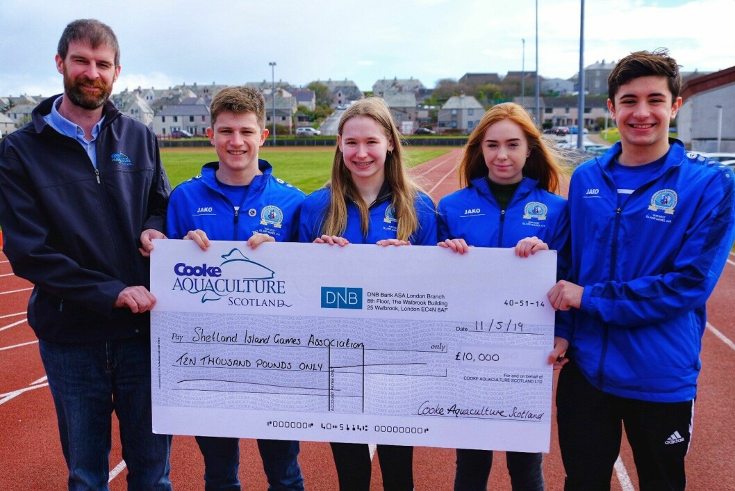 Cooke's Shetland area manager David Brown, left, with members of the Shetland swimming team.