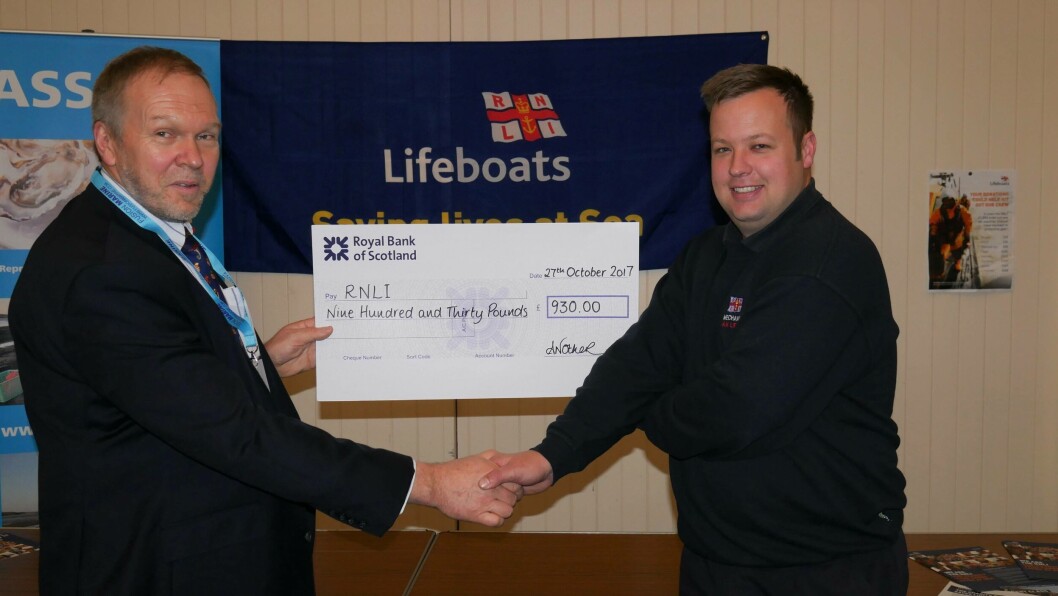 Nick Lake, chief executive of the ASSG, presents RNLI lifeboat mechanic Tom Kennedy with a cheque for £930. Photo: Gareth Moore/FFE