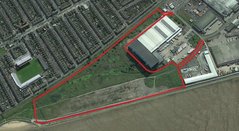 The site of the proposed salmon RAS, outlined in red, which is west of Grimsby Docks. The photo also shows Blundell Park, home of Grimsby Town FC, and streets of terraces homes separated from the site by a road and railway line.