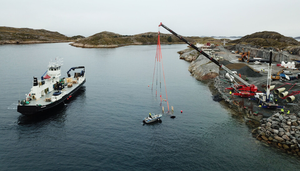The picture shows the work of installing the first inlet pipe, seen hanging by the straps from the crane.