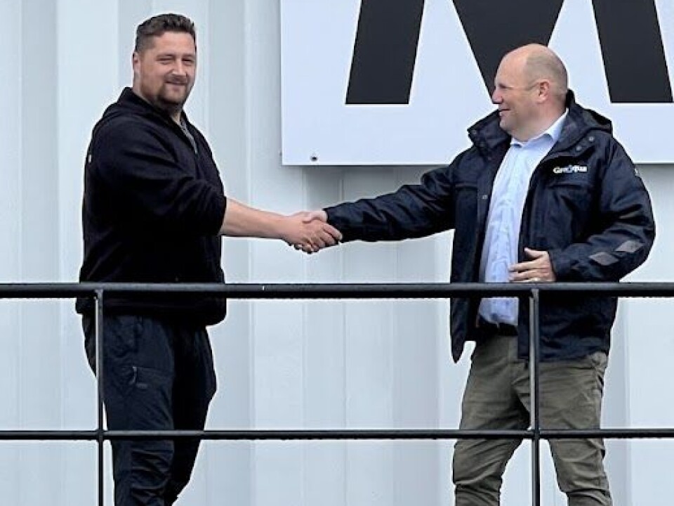 Steffan Gaard, site manager in Oyndafjørður, and GroAqua barge project manager Ólavur Thomsen, right, shake hands.