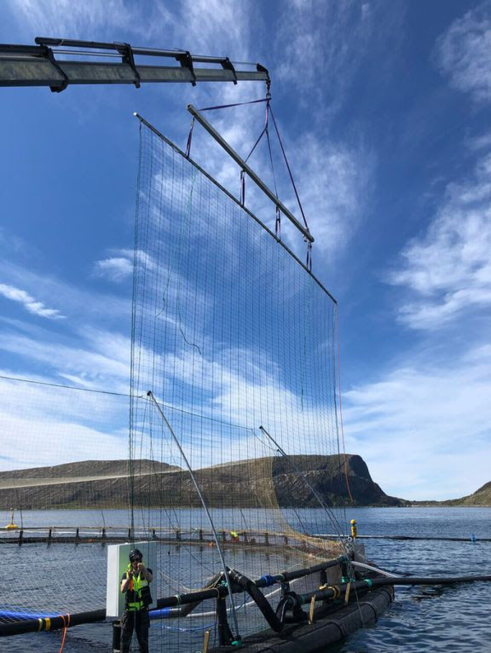 A section of Harbor Fence being moved at a salmon farm.