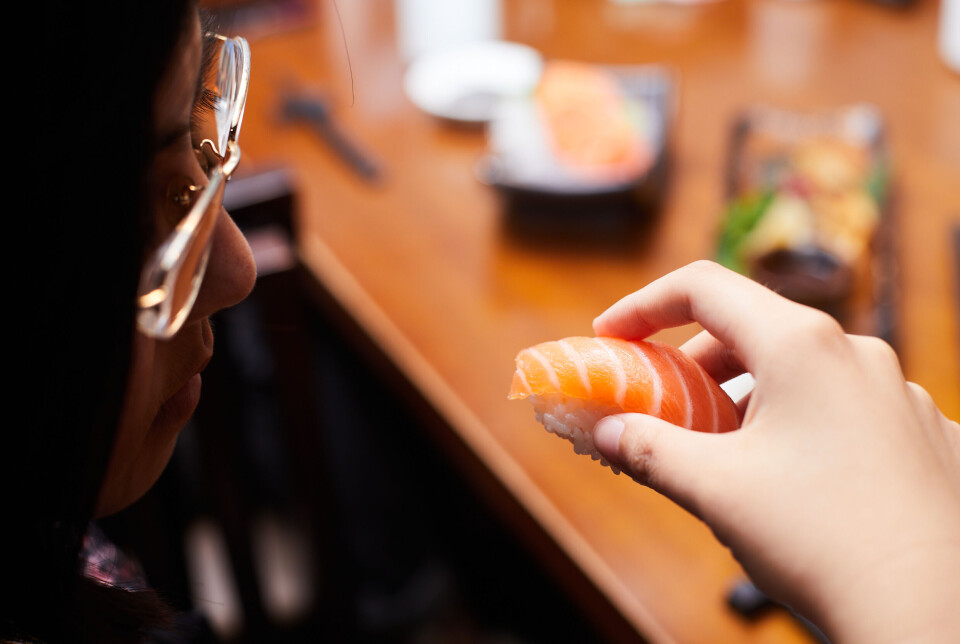 A diner eats salmon sushi in Japan.