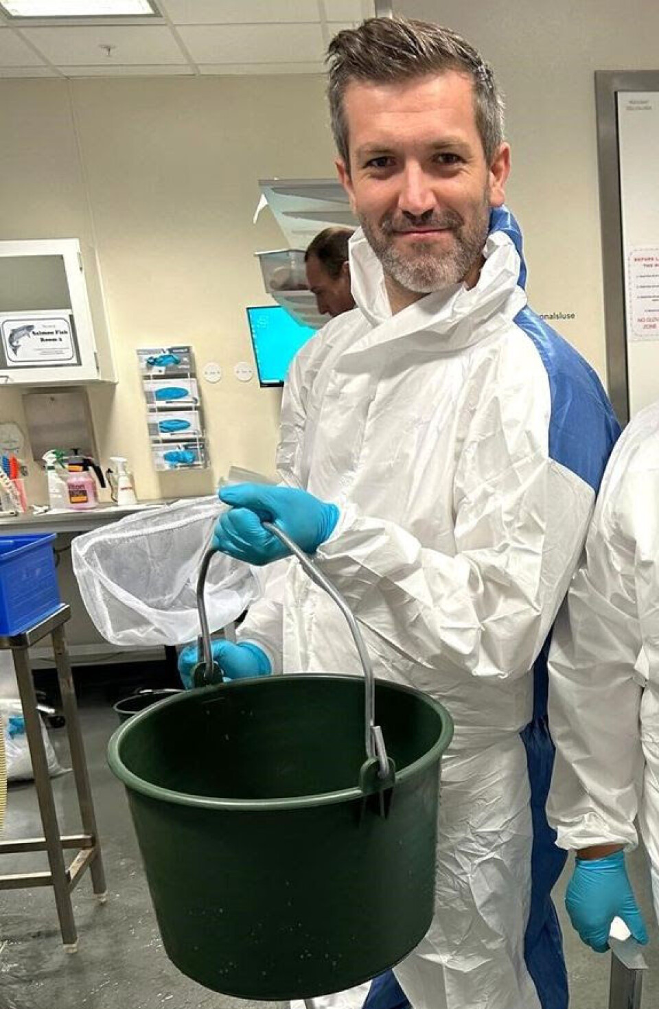 Researcher Sergio Rocha has worked with Røsvik on the project. Here, with a net and a bucket, he searches for fish in the tanks that show signs of illness.