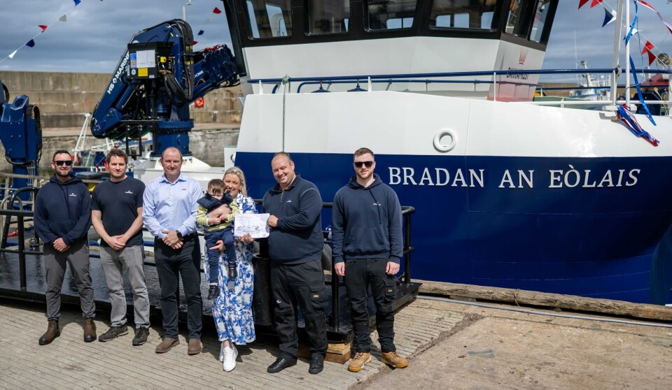 Bakkafrost Scotland Ian Laister, (in the light blue shirt), standing alongside the Anderson family, with mum Janice Ann holding three-year-old Noah and dad Billy holding a picture of the boat coloured in by Noah.