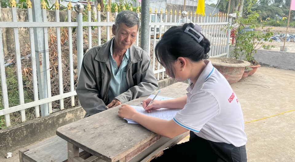 A researcher from RMIT University Vietnam interviewing a shrimp farmer about welfare and environmental practices.