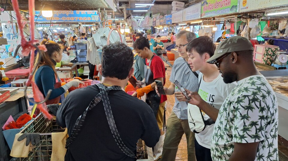 Professor Dave Little, Arnan Hirunratanakorn and Dr Simão Zacarias carrying out observational research at a fresh food market in Thailand where live fish are sold.