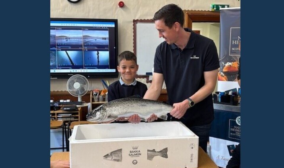 Craig Johnstone, marine site manager at Gigha, helps a pupil get a feel for salmon during the workshop at Tarbert Academy.